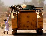 soldier shares meal with Iraqi child from APC - US DOD image